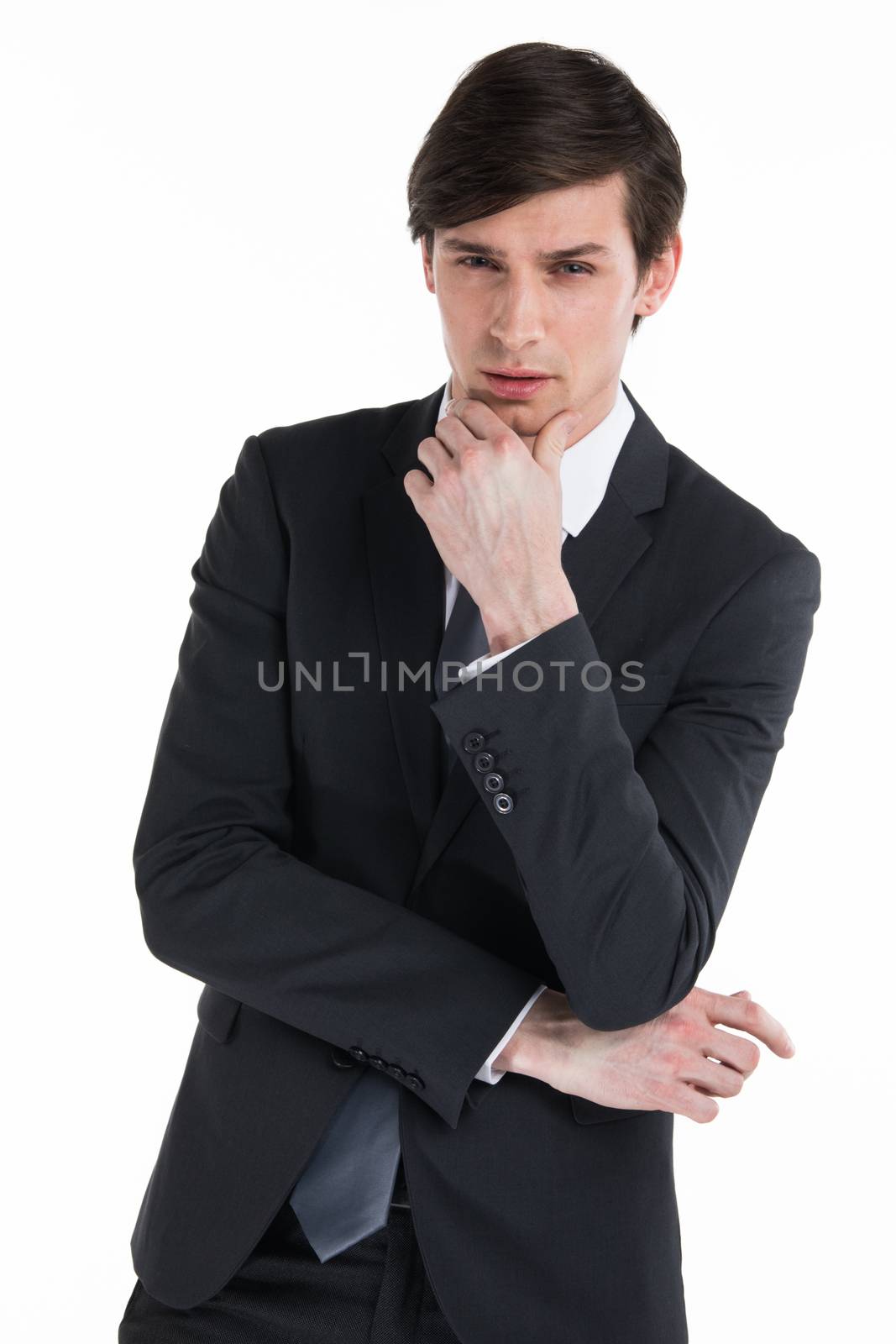 Frowning business man thinking over serious decision. Confident young man in formal suit touching chin