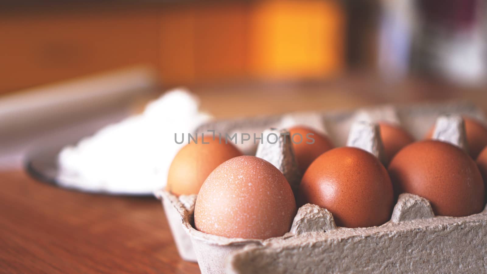 Ingredients for baking homemade bread. Eggs, flour. Wooden background, side view. Soft focus and light