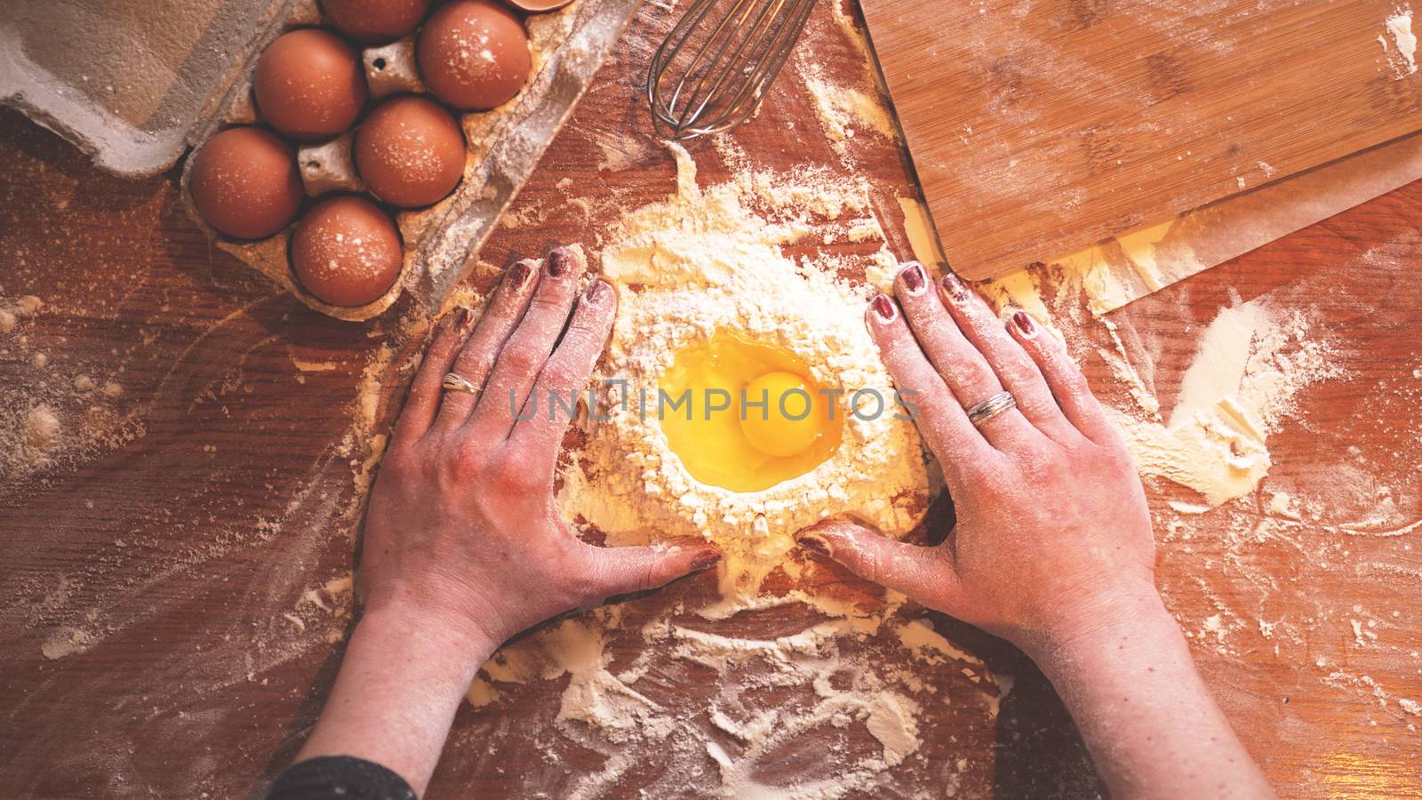 Professional female baker cooking dough with eggs and flour for Easter baking