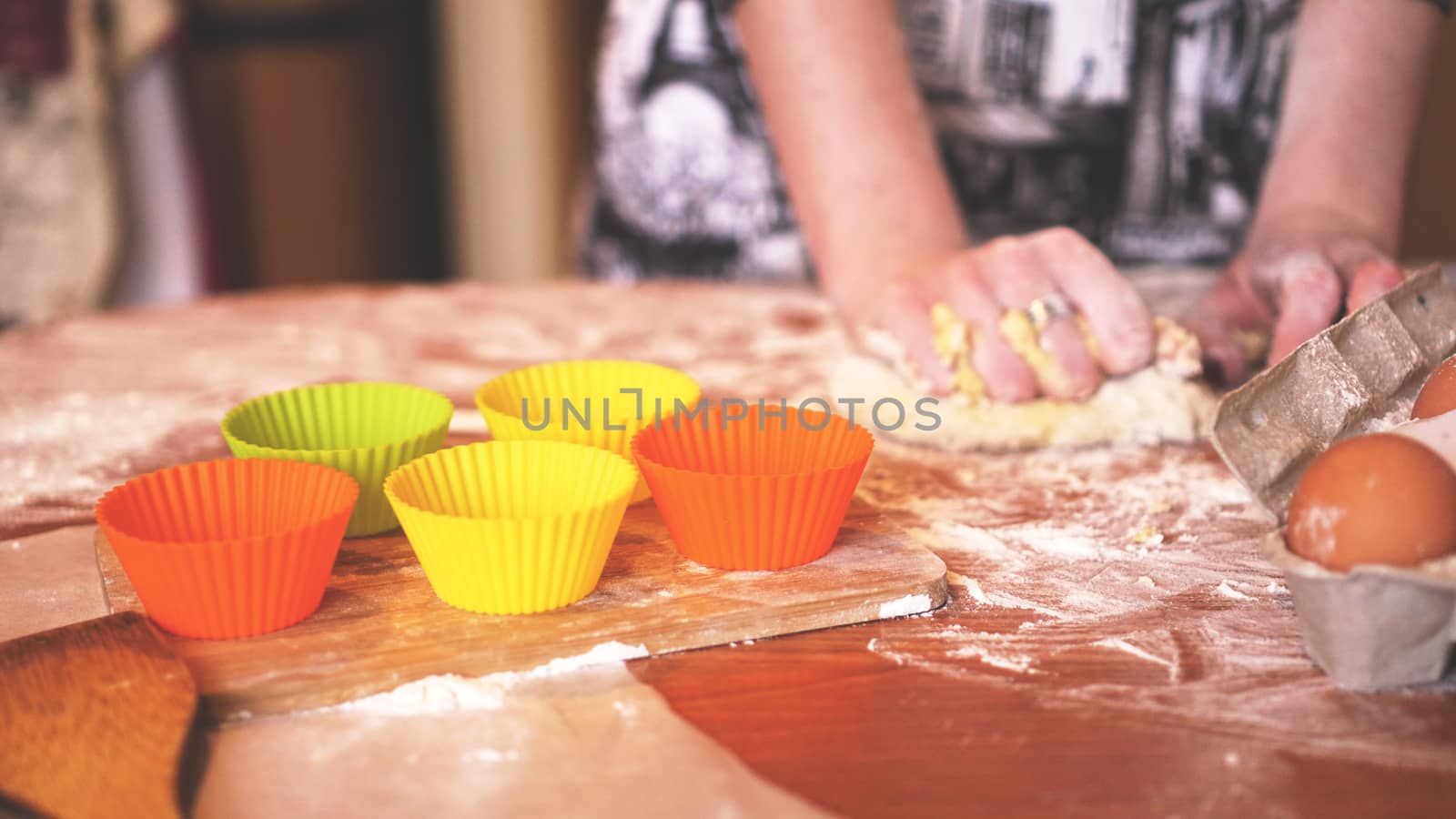 Cooking and home concept - close up of female hands kneading dough at home. Soft focus