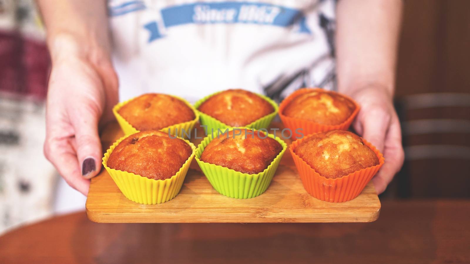 Homemade caramel muffins in a baking dish in the hands of the confectioner. Dessert for gourmet. Selective focus