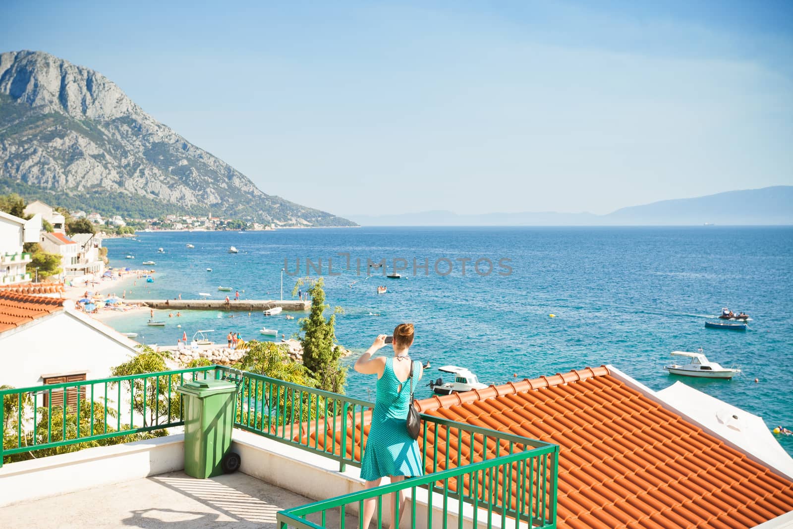 Brist, Dalmatia, Croatia, Europe - A woman taking a picture of the beautiful bay of Brist