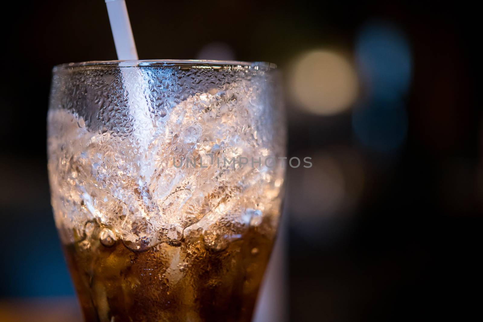 glass of cola with ice and straw by antpkr