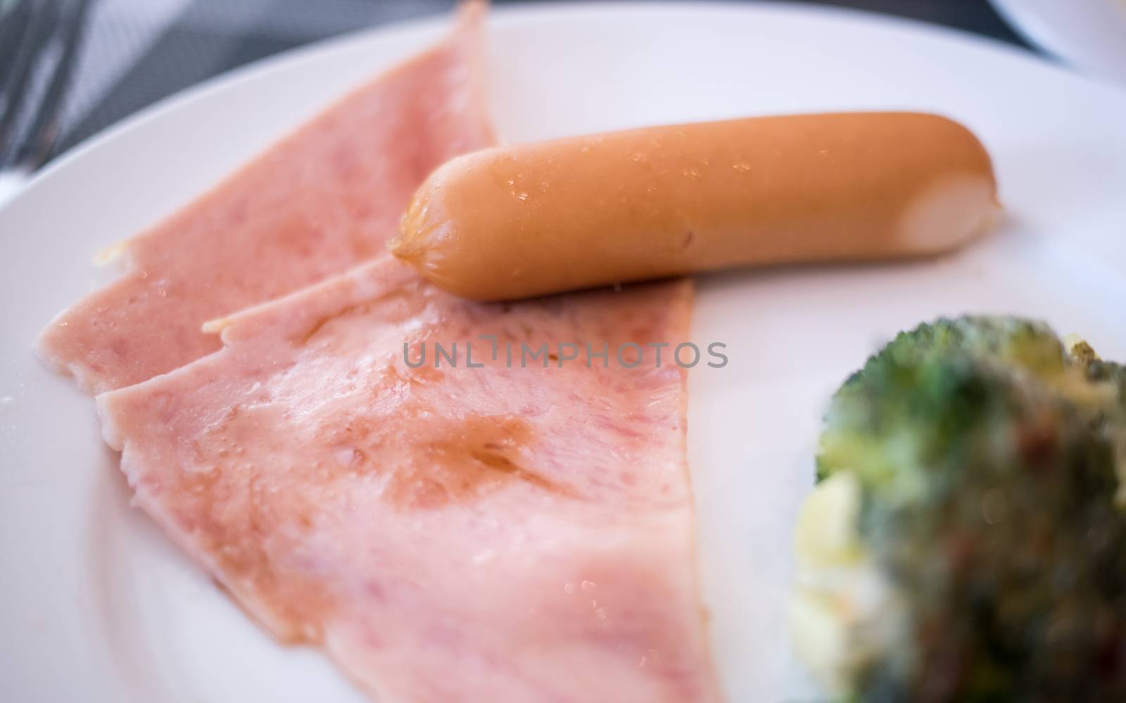 sausage with ham on the white plate on breakfast table by antpkr
