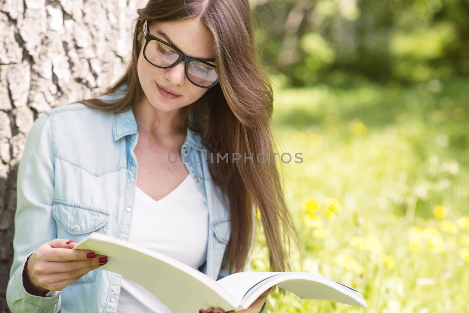 Woman in park with magazine by ALotOfPeople