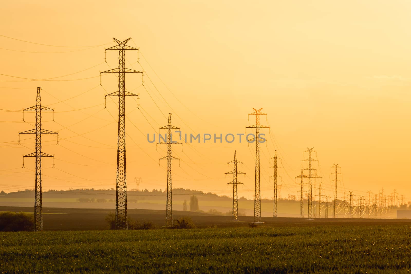 High voltage post tower sky sunset and field