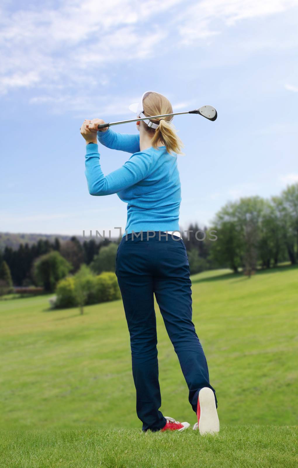 Caucasian female golfer hit a golf ball by golf-club driver