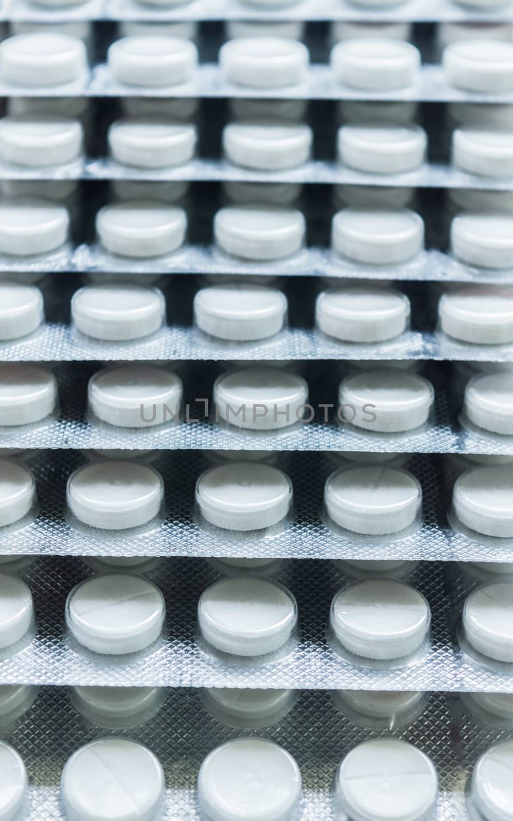Heap of Capsules packed in blisters, round patterned shaped medicine tablet or antibiotic pills. Medical Pharmacy theme. Close up with copy space. by sudiptabhowmick