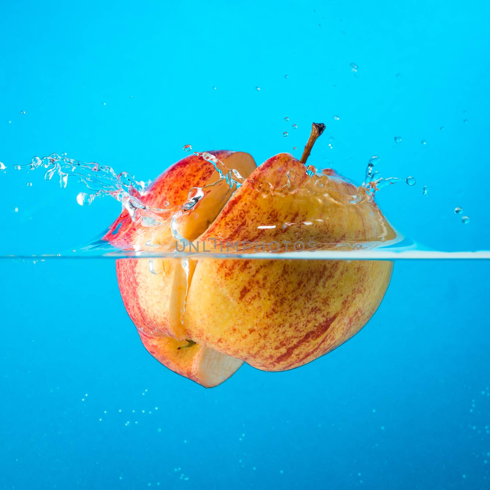 Water splash. Apple under water. Air bubbles and transparent water.