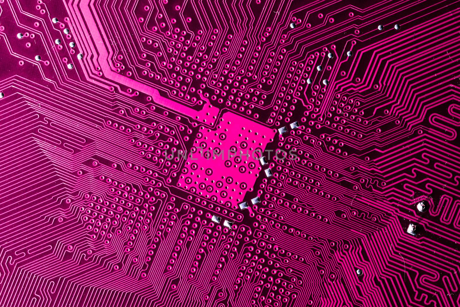 Close up photo of pink printecd circuit board with solder points