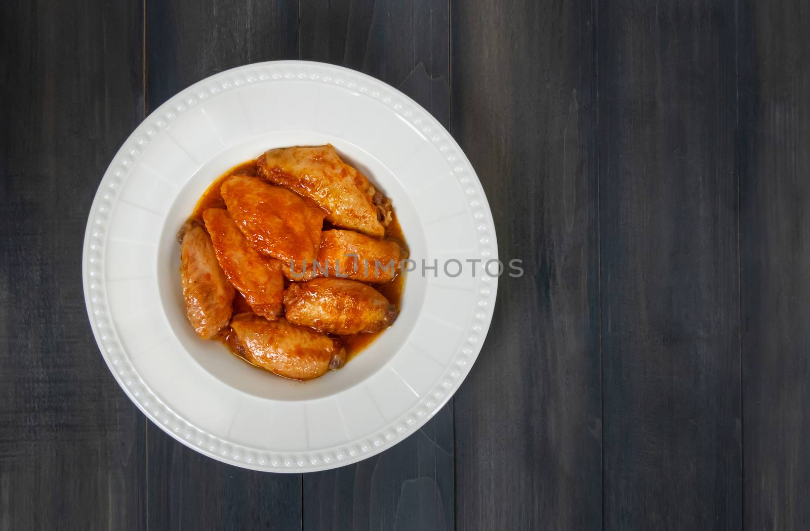 Baked chicken wings with spicy sauce. Food background with copy space. Top view