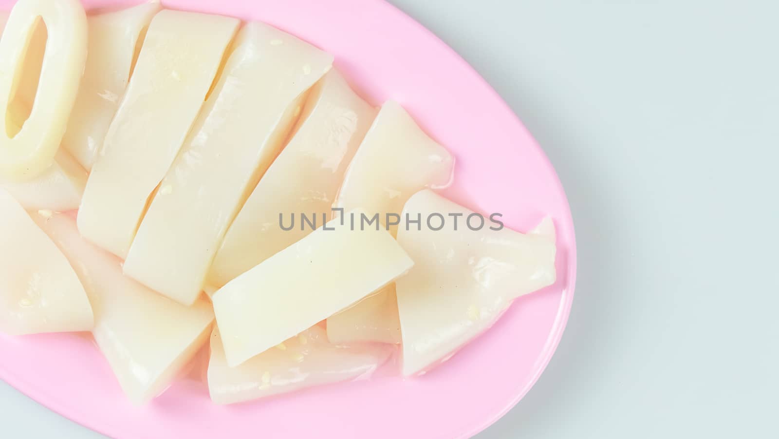 top view raw squid sliced on pink plate