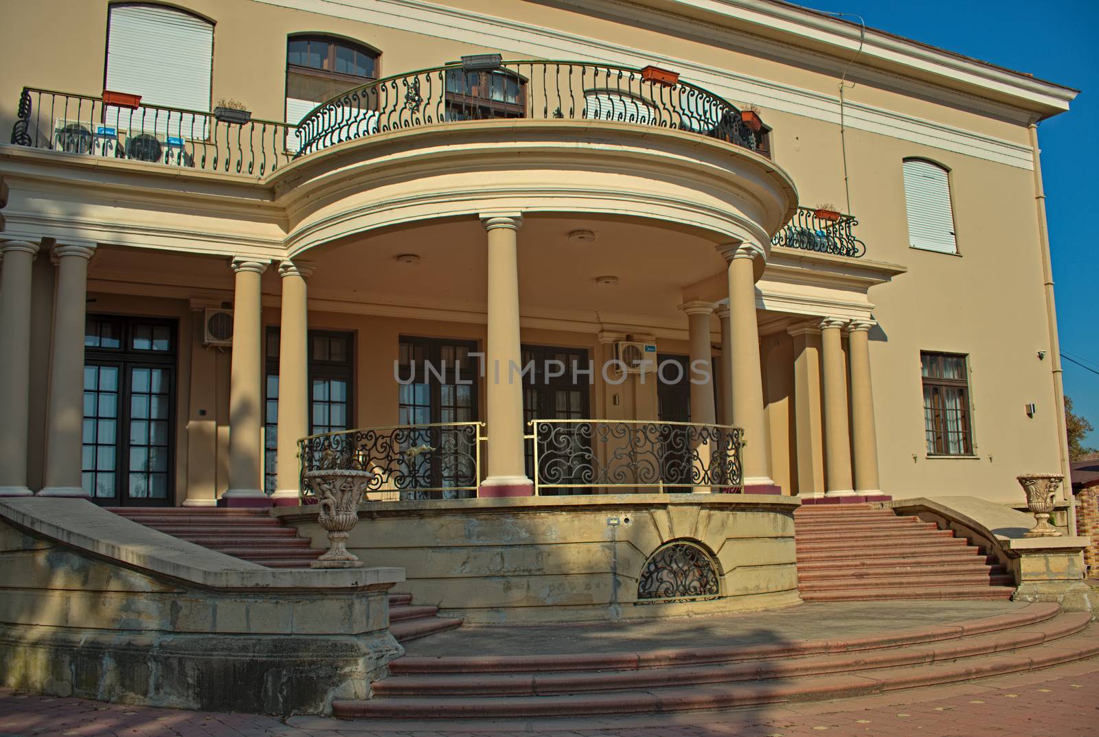 Outside view on entrance into villa with doors, stairs and windows