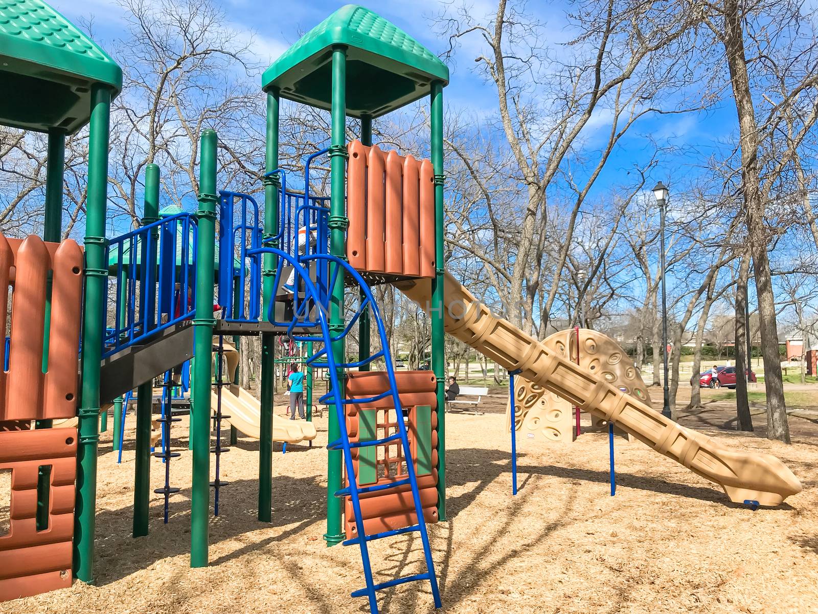Kids running at colorful playground during wintertime in Lewisville, Texas, USA.