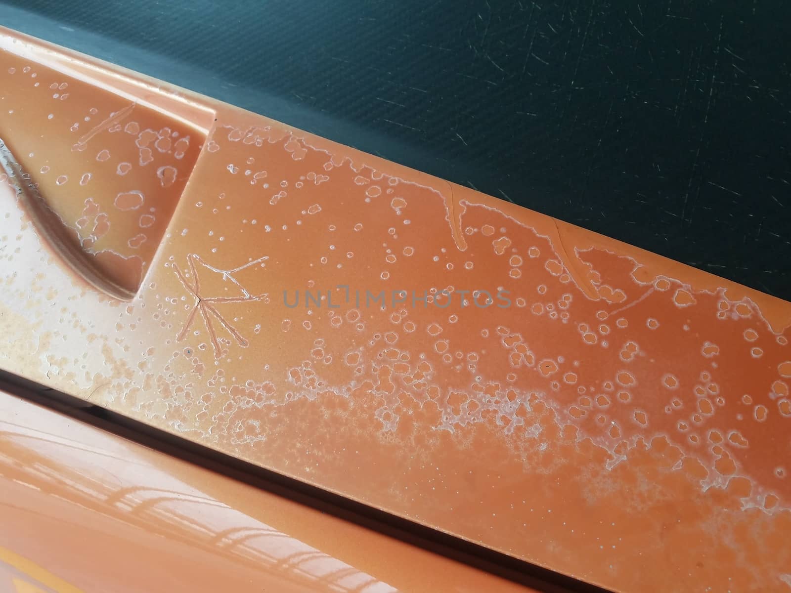 corrosion or damage on weathered orange car or automobile