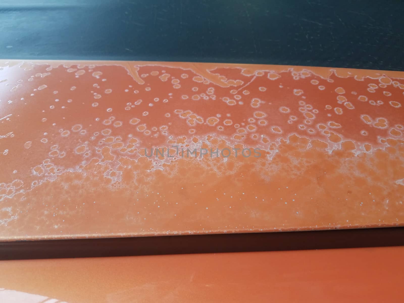 corrosion or damage on weathered orange car or automobile