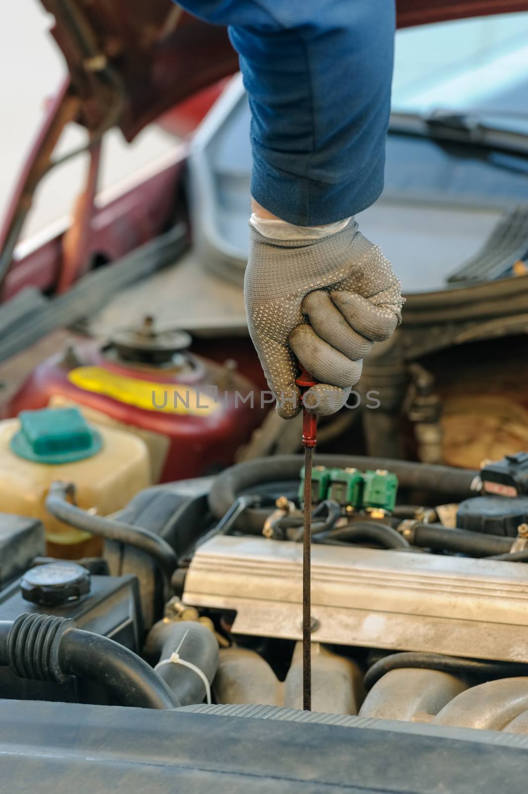 engine oil changing and level control with dipstick at old dirty car with liquefied petroleum gas system