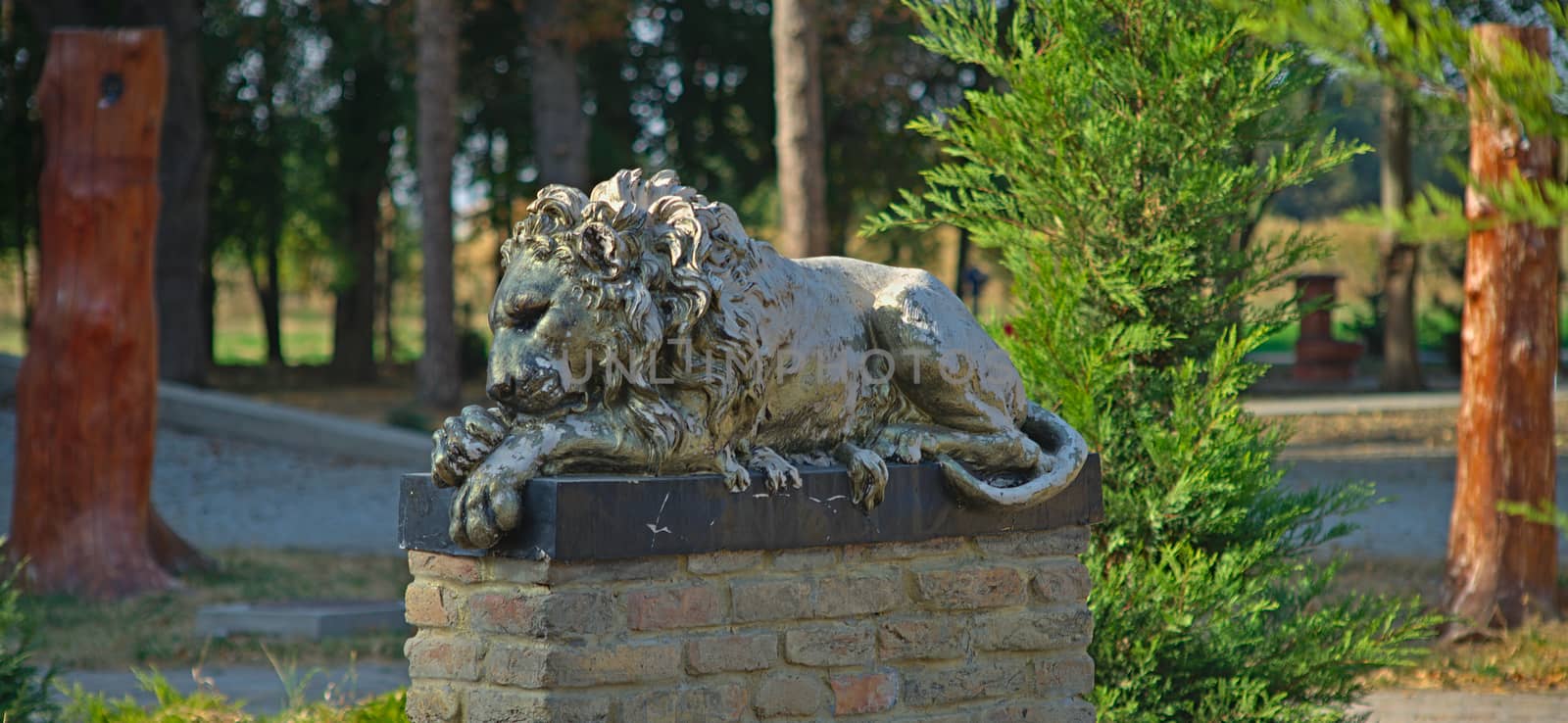 Bronze statue of a lion on bricks pedestal