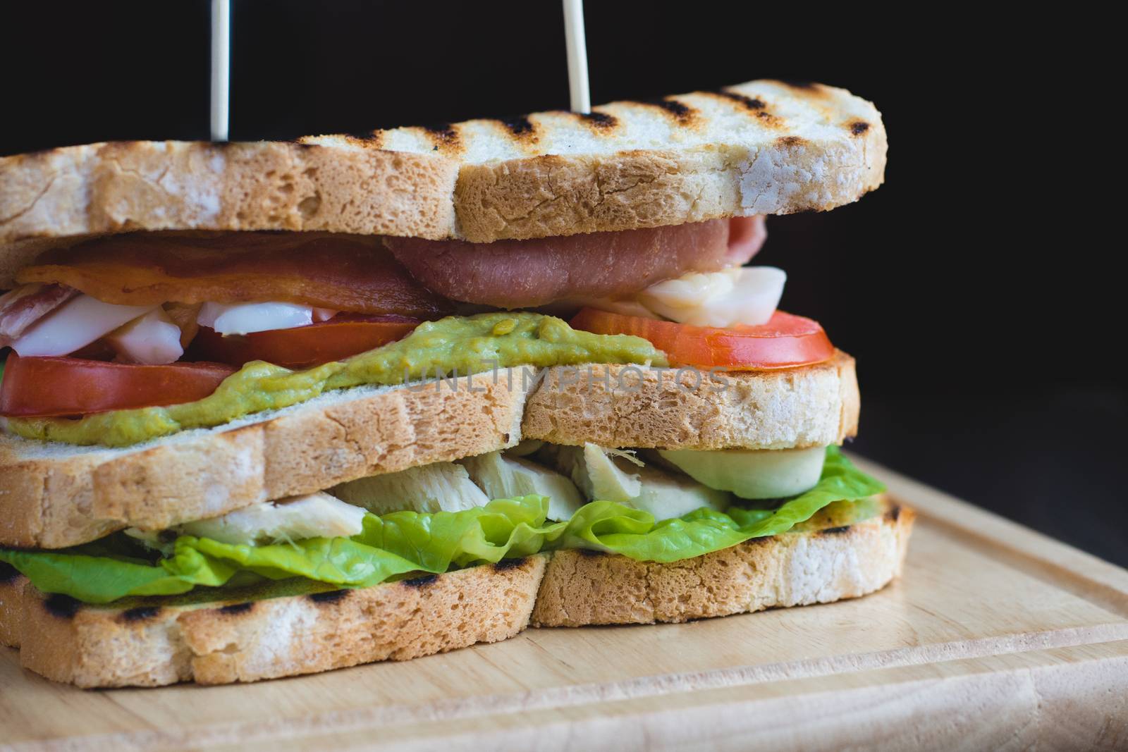 Toasted Triple Decker Club Sandwich with chicken, bacon, avocado, tomato and lettuce