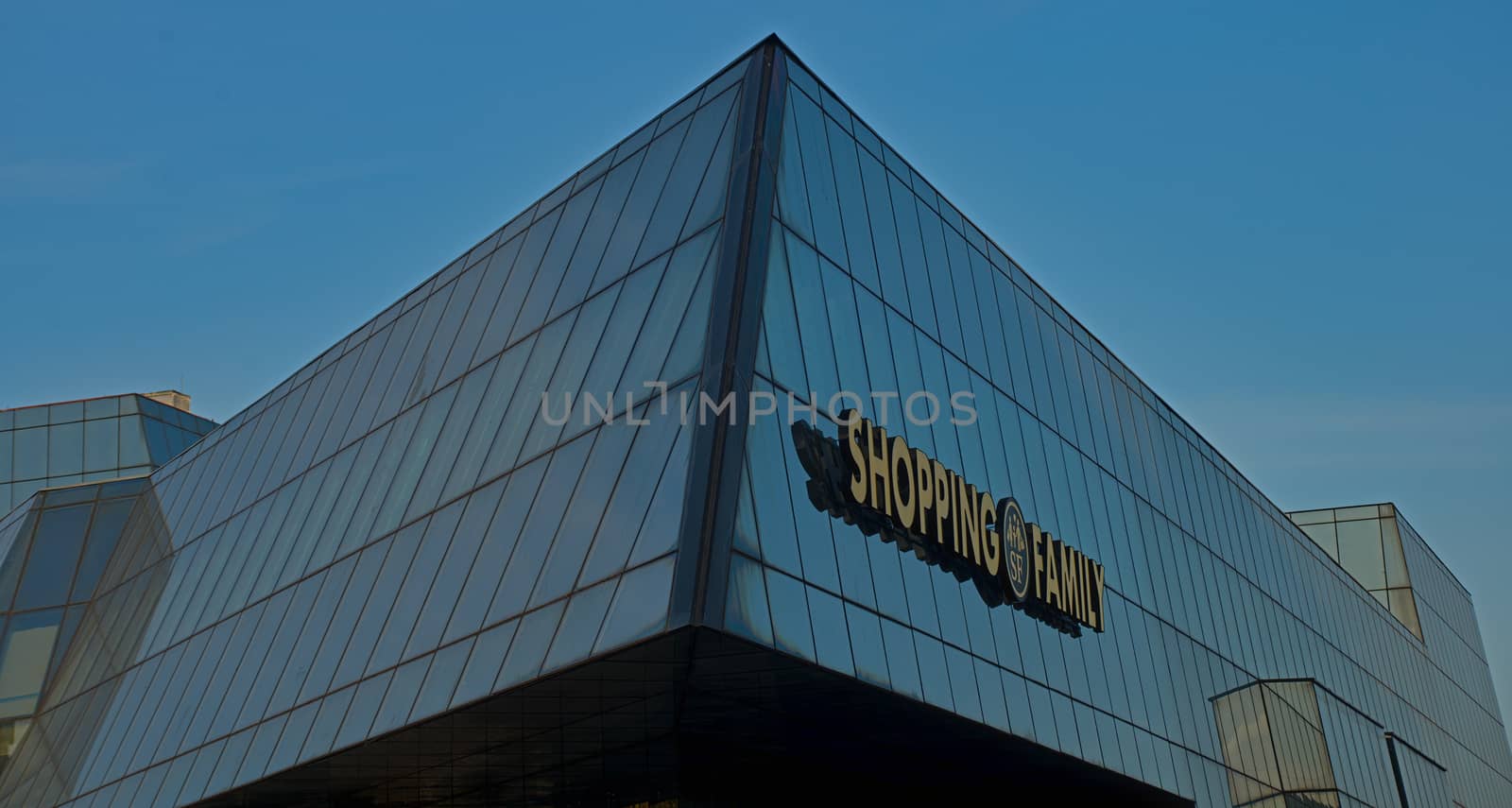 Modern glass building with sign with sign shopping family
