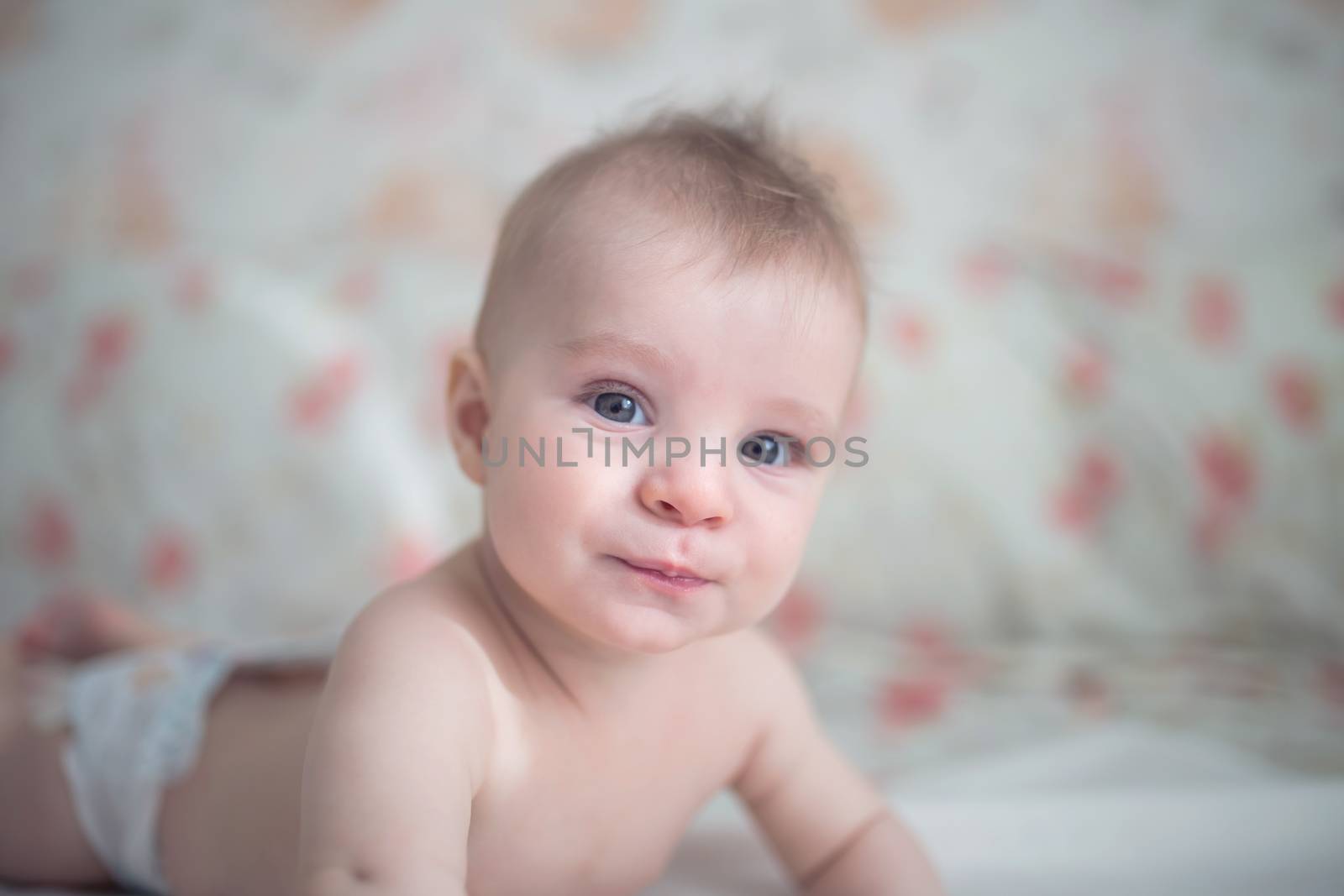 Cute baby boy relaxing in bed in nursery