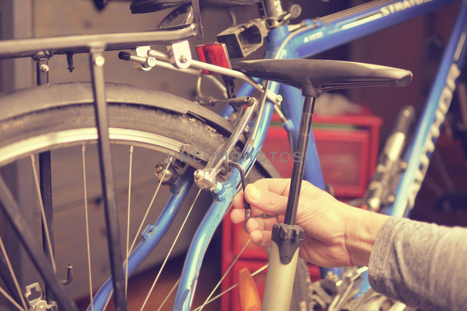 Mechanics hand repairing bicycle in bike workshop. Bike maintenance and sport shop concept.