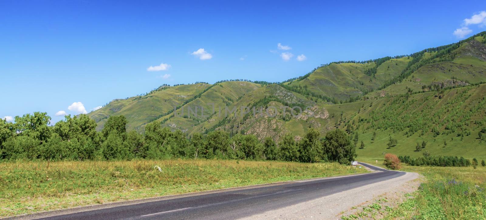 The road among the mountains in summer and the blue sky with clouds