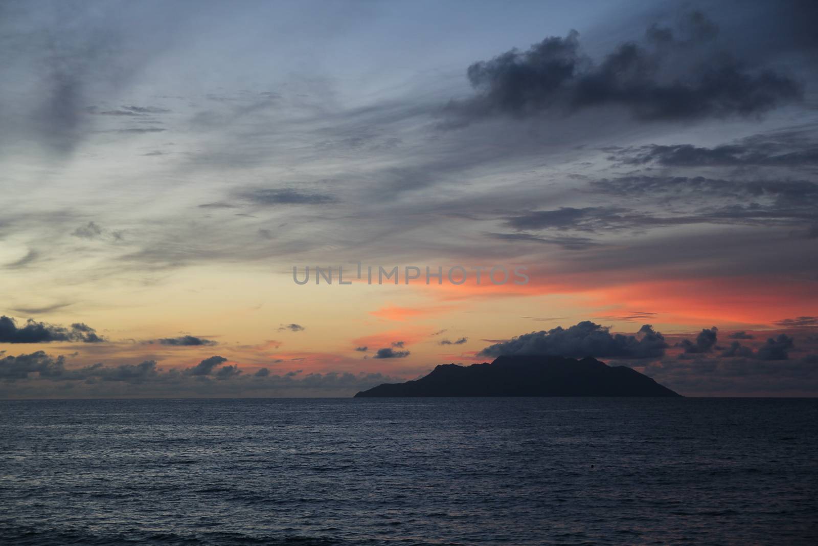 uninhabited island in the ocean against the sunset