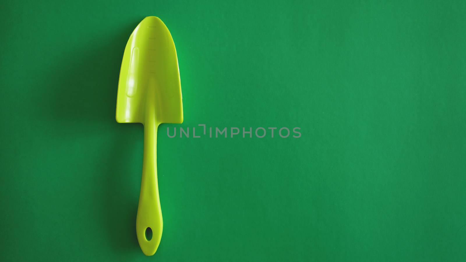 Green garden tool on green background - top view by natali_brill