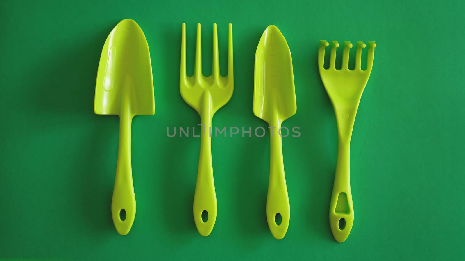 Set of green garden tools on green background by natali_brill