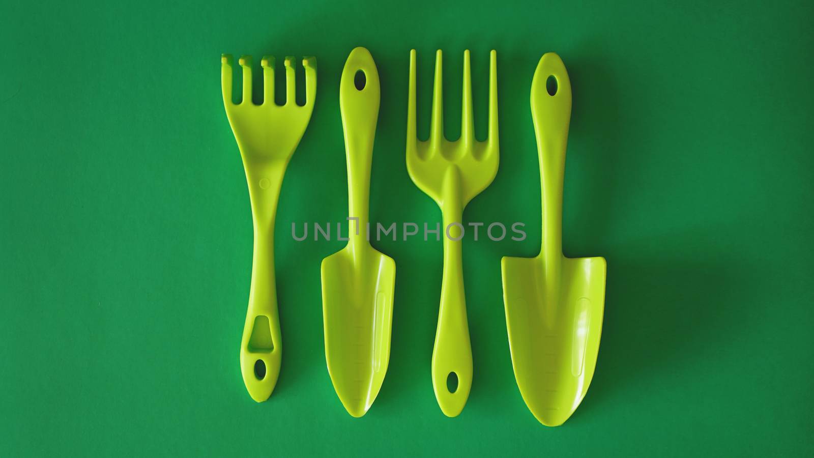 Set of green garden tools on green background by natali_brill