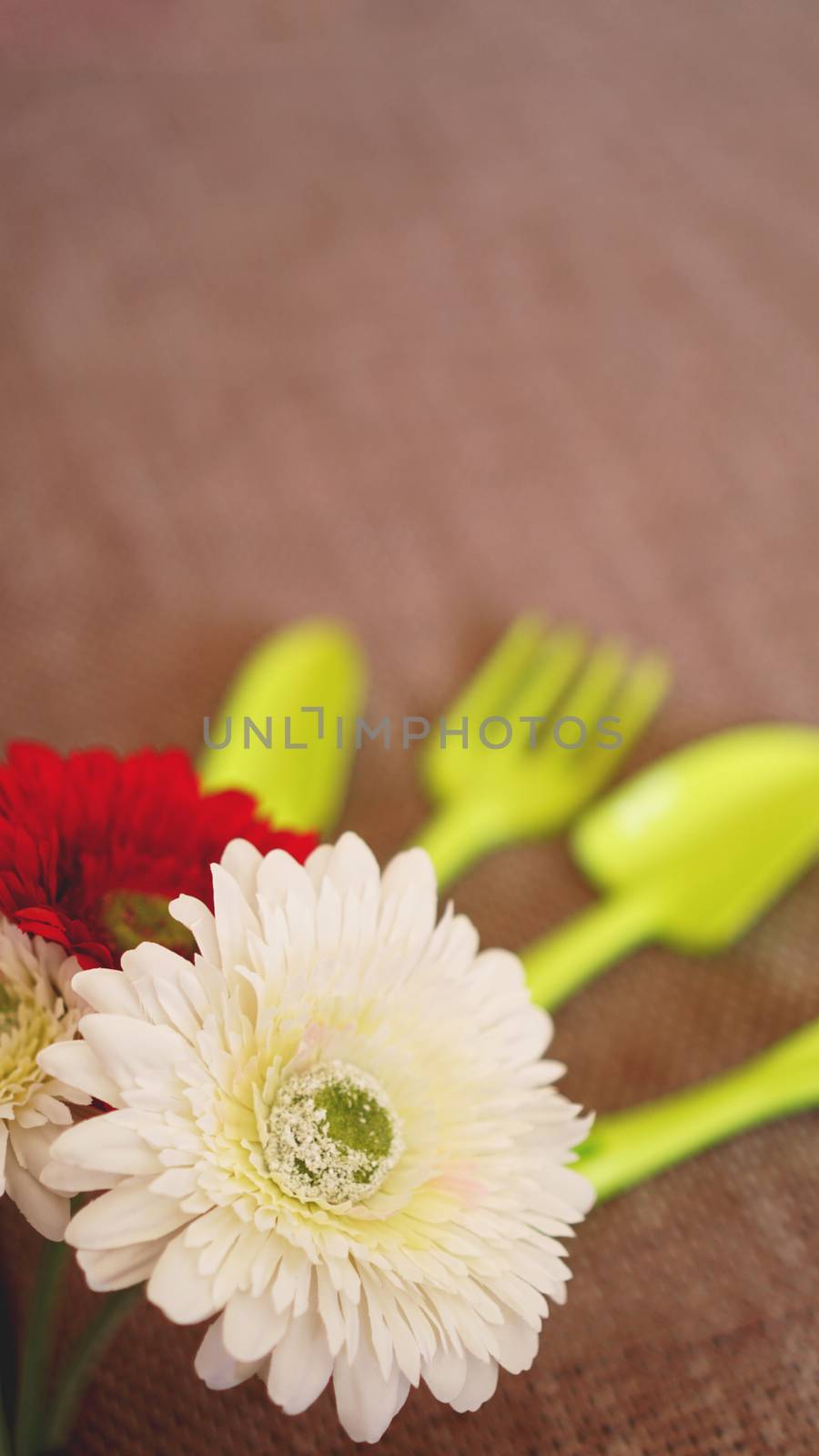 Gardening background. Gardening green tools and flowers - soft focus - vertical format