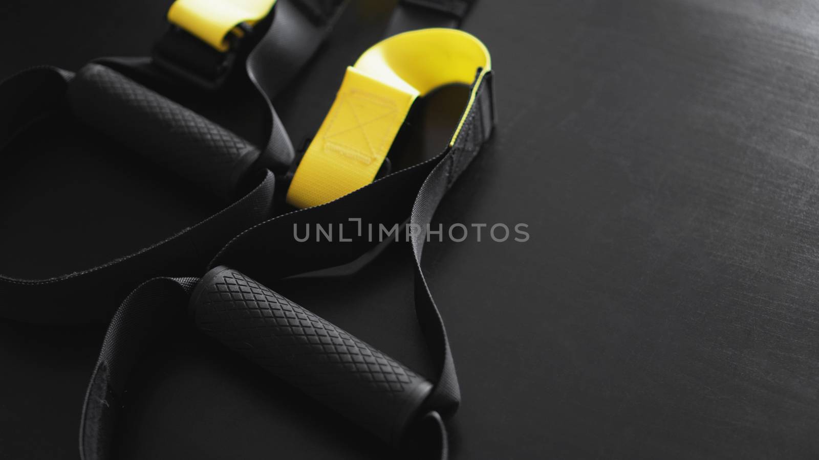 Black and yellow strap functional training equipment on grey background. Sport accessories. Fitness and Gym workout items for Healthy. Banner TRX