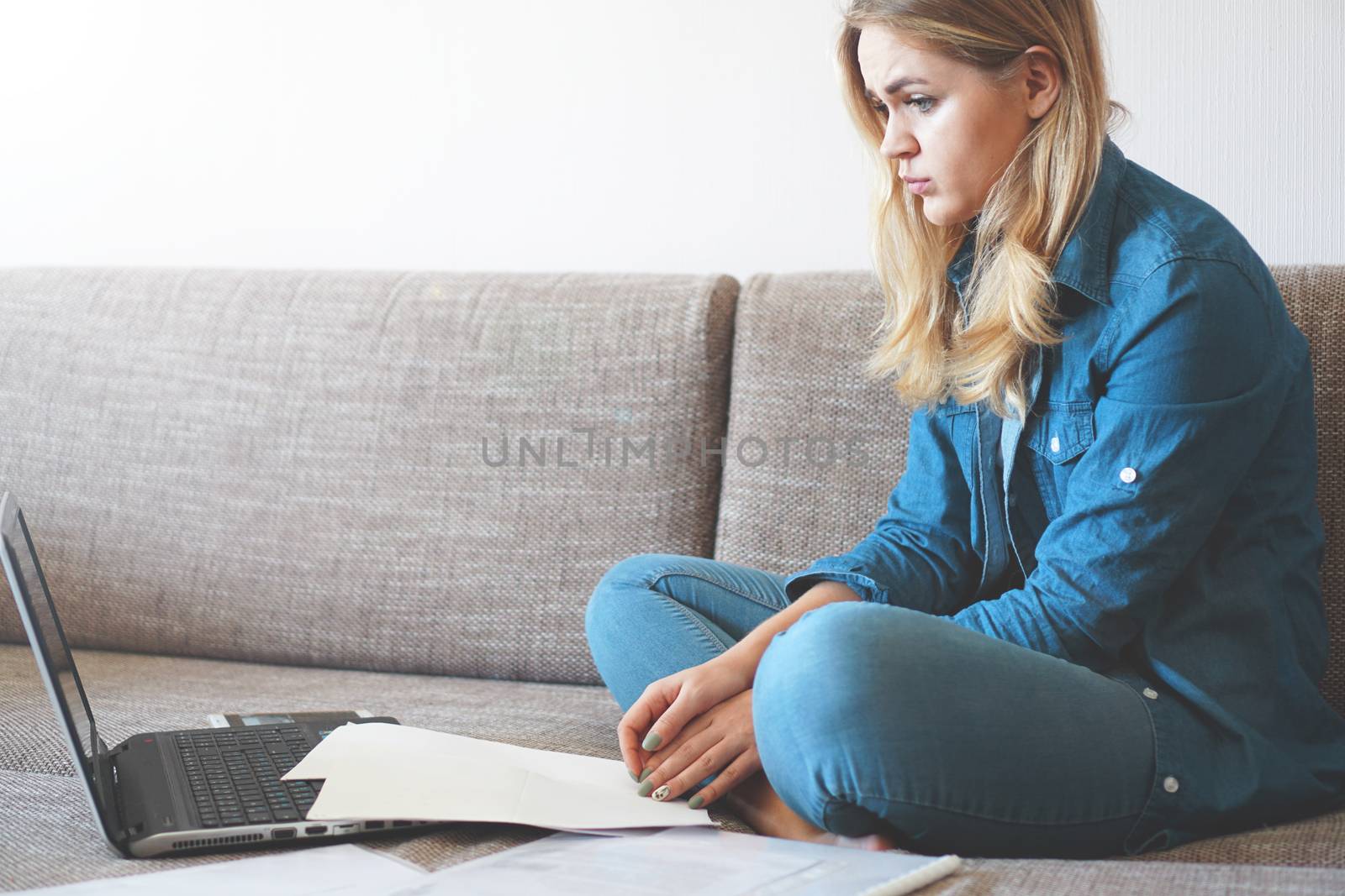 Serious woman focused on finding information. Sitting at home in front of a laptop. The concept of business and online student learning