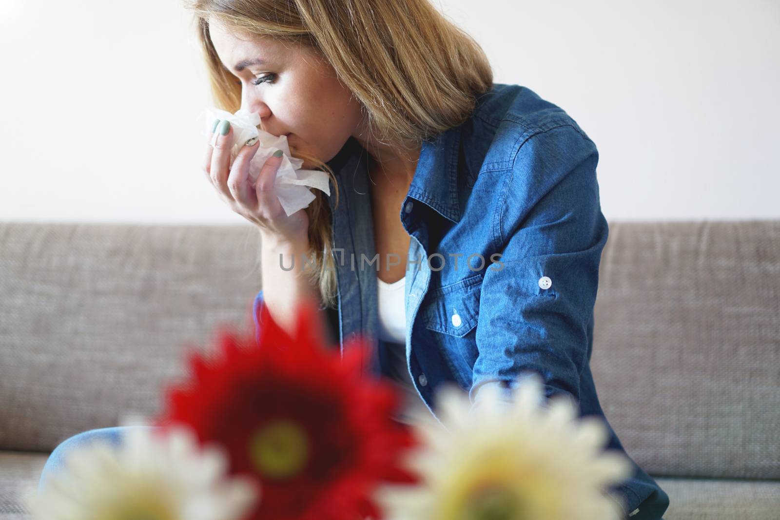 Spring cold or allergies. A young attractive girl is allergic to flowers, uses a napkin at home
