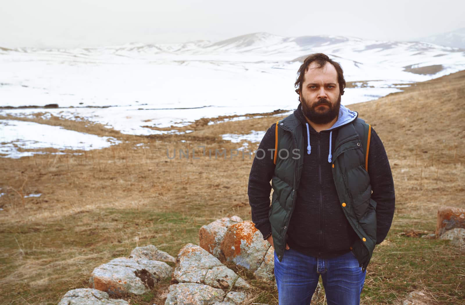 Man in the winter steppe looking at camera by Novic