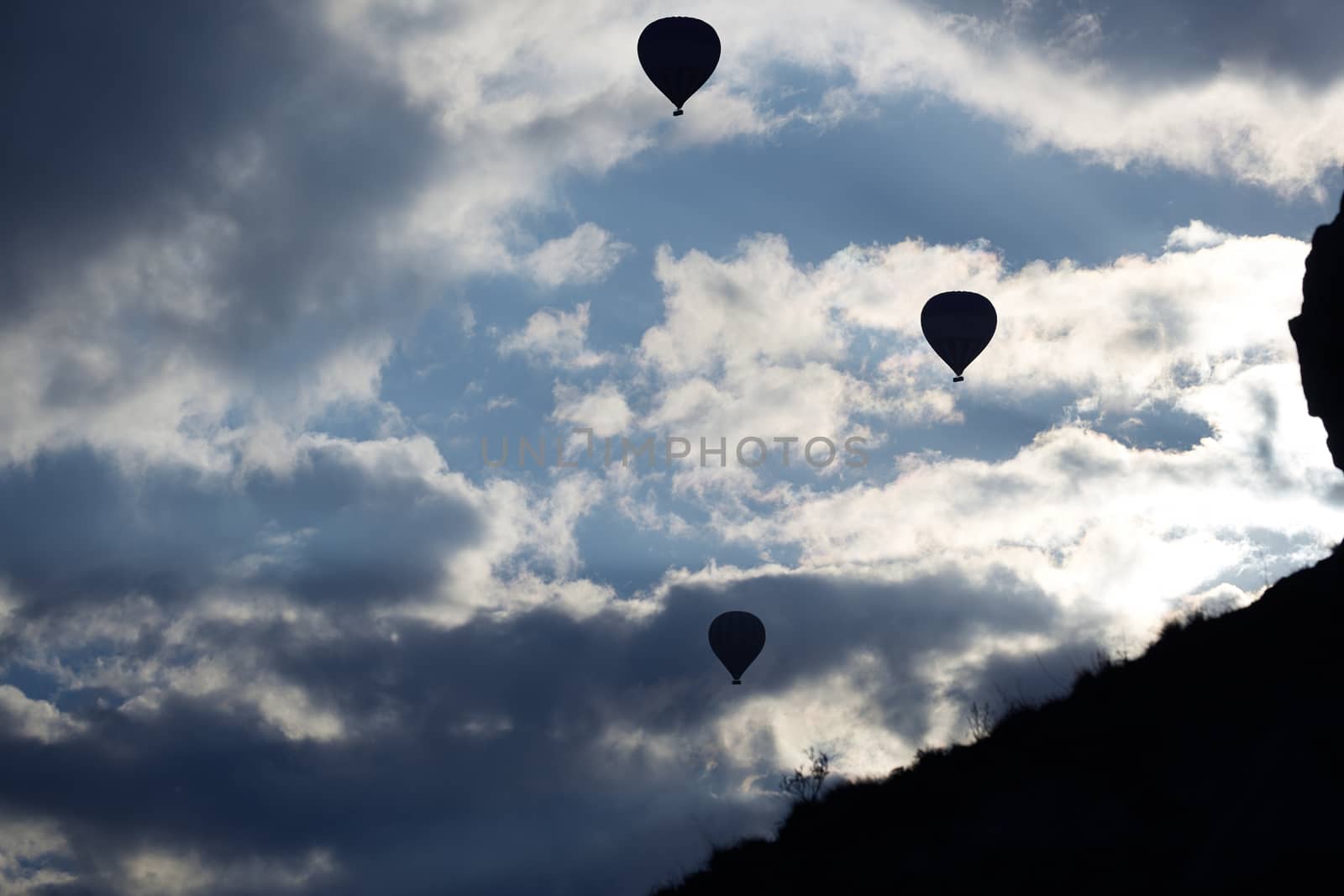 Silhouettes of the hot air balloons flying over the mountain