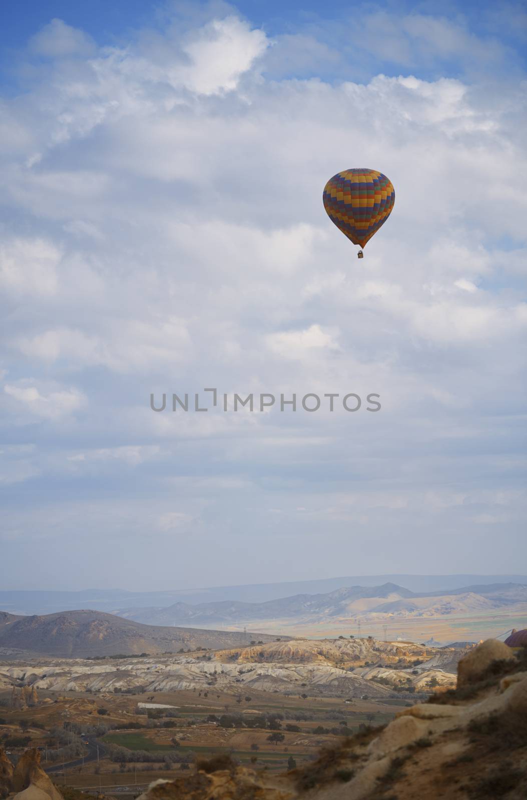 Hot air balloon flying over the rocky land by Novic