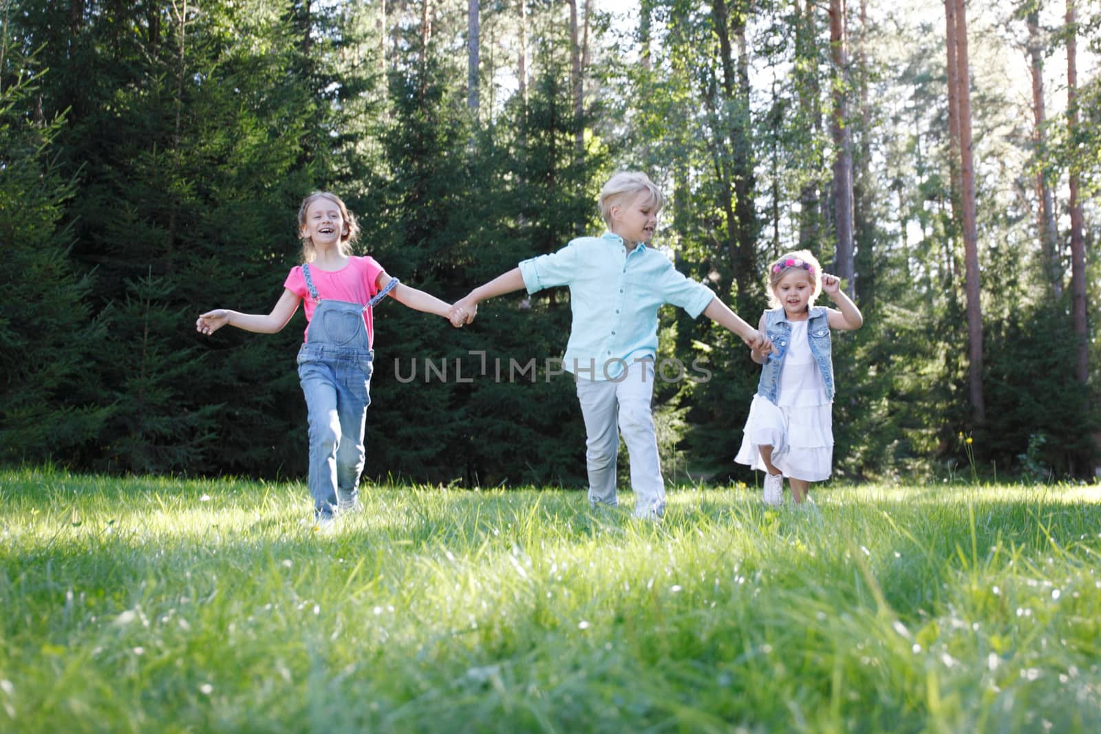 Group of young children running towards camera in park