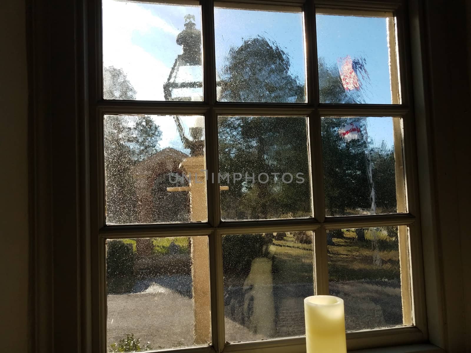 candle, thick glass window, and light and flag outdoor