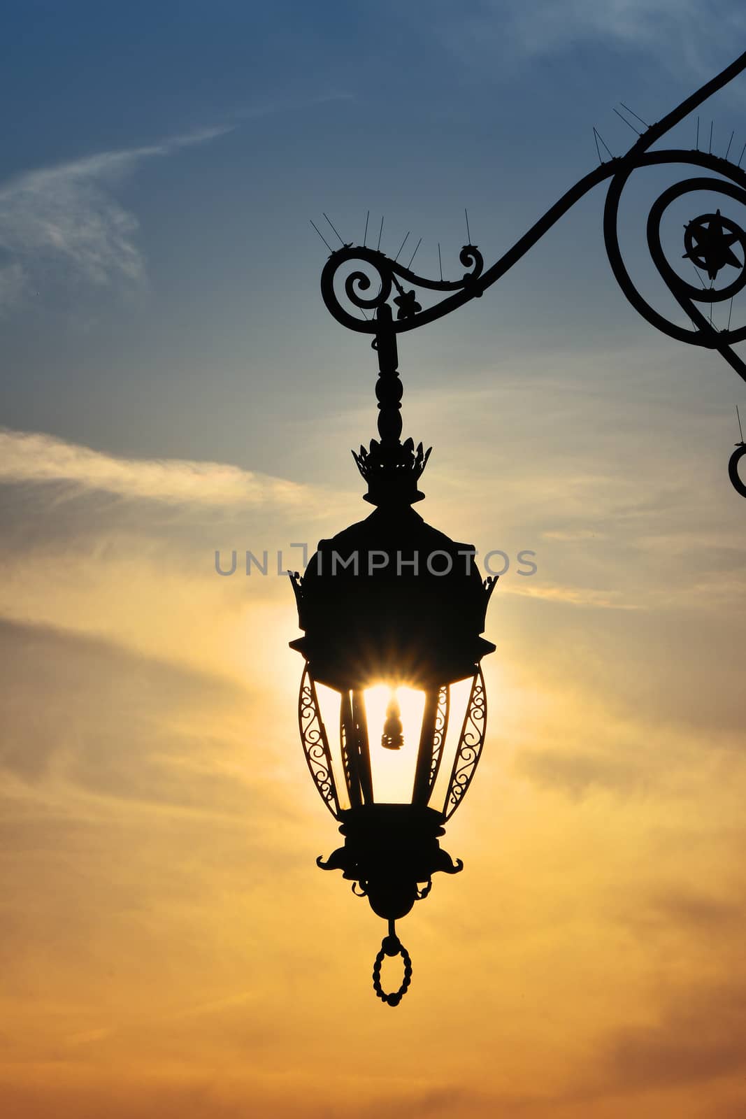 Antique street lamp lantern over sunset sky by BreakingTheWalls