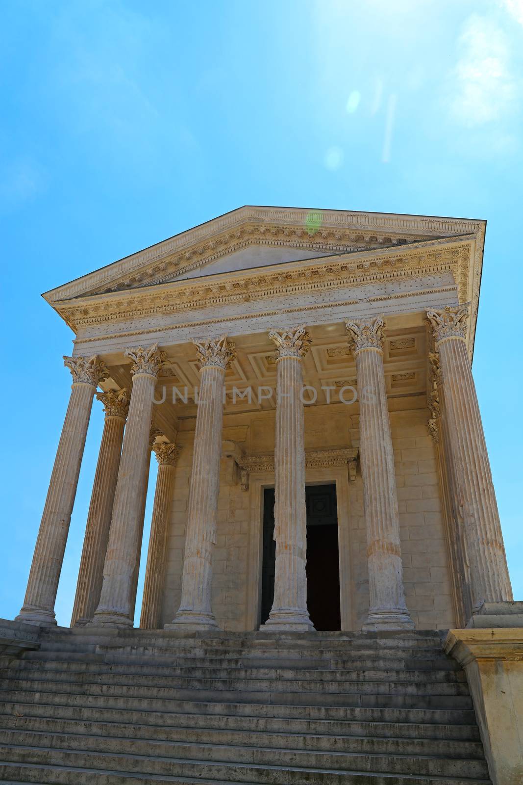 Front view of Maison Carree (square house), ancient building in Nimes, France, one of the best preserved antique Roman temple facades, low angle