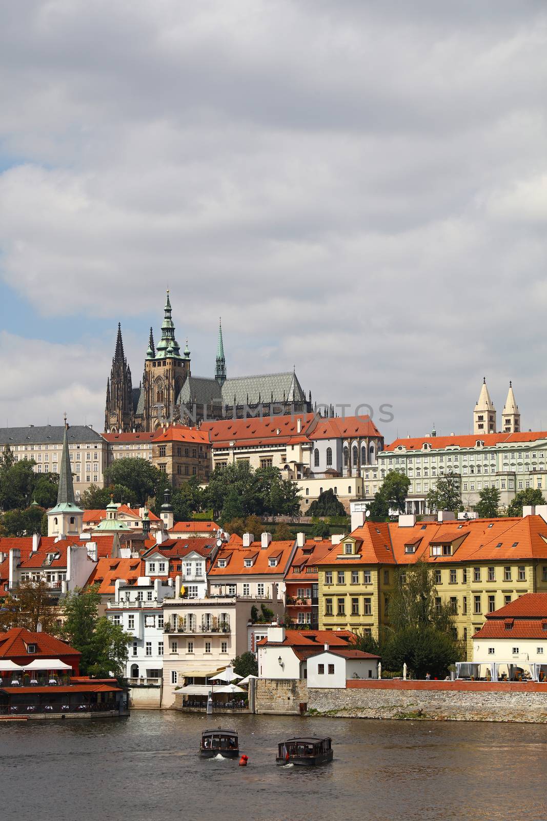 View of Prague lesser old town with Royal castle palace and Saint Vitus Cathedral over Vltava river and blue sky