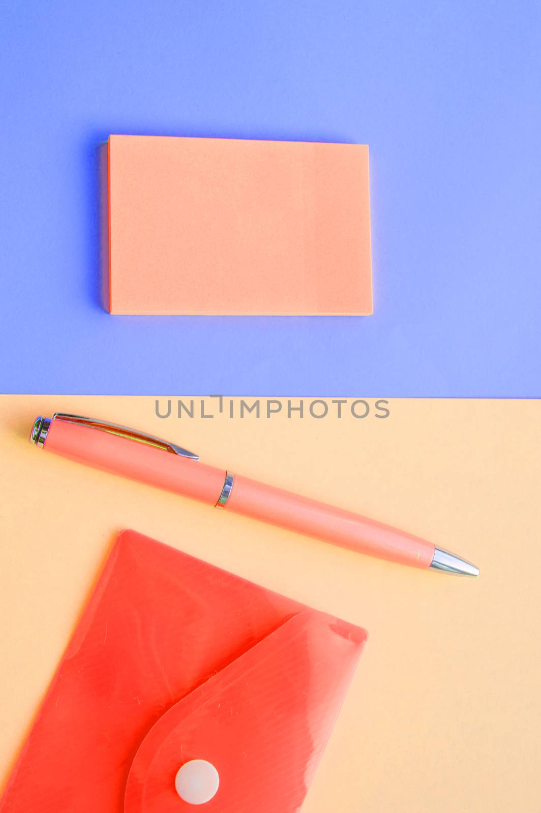 Creative vertical flat lay, top view, office space stationery on coral and purple background by claire_lucia