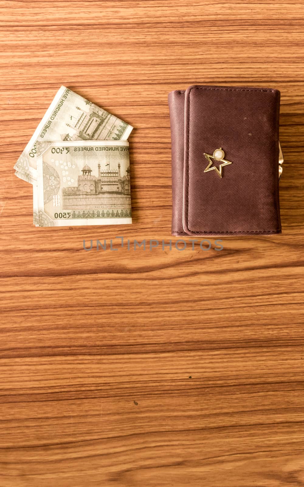 Indian five hundred (500) rupee cash note in brown color wallet leather purse on a wooden table. Business finance economy concept. High angel view with copy space room for text on front side of image by sudiptabhowmick