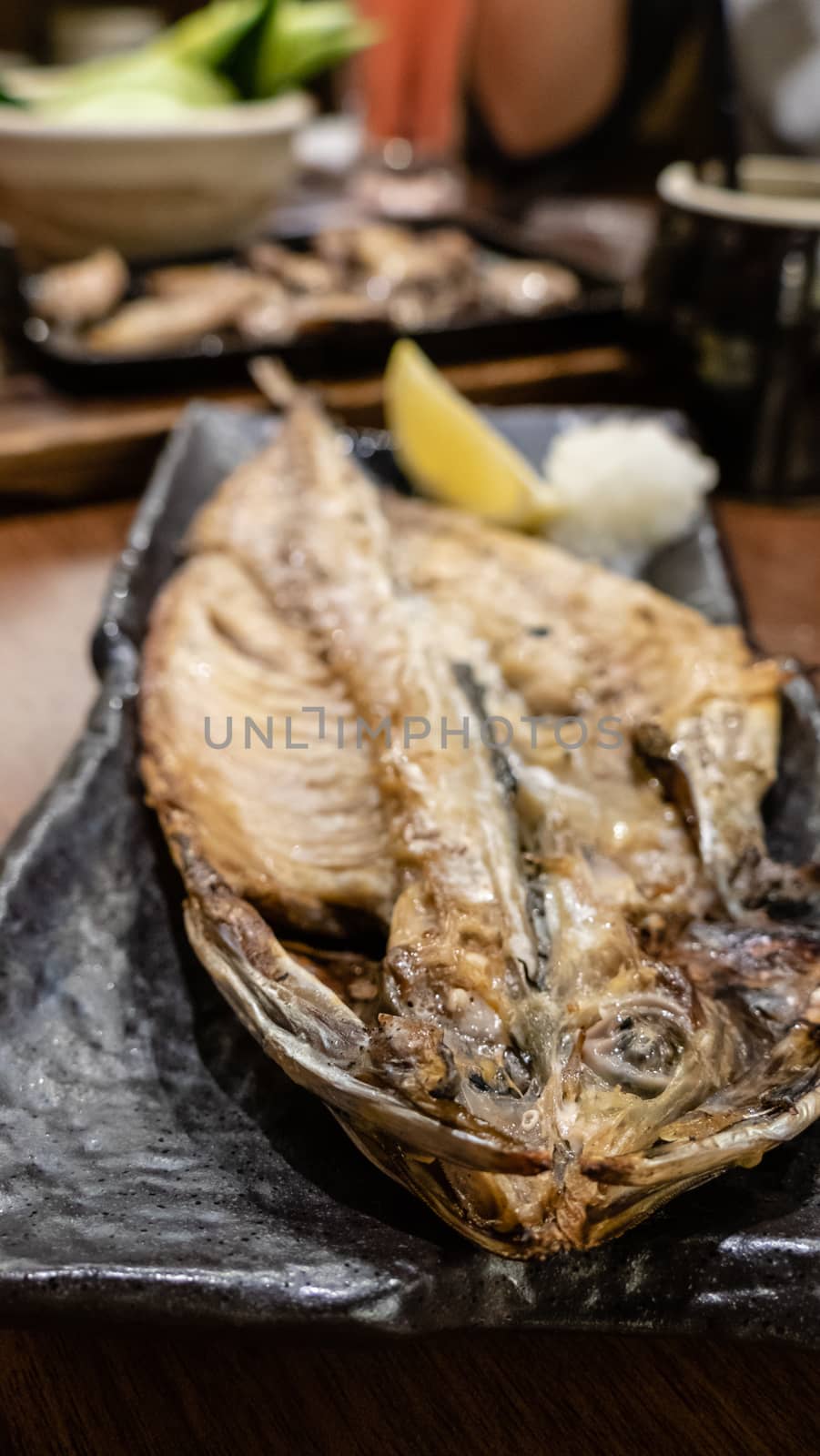 Fish served while grilling on metal dish at Japanese izakaya style restaurant