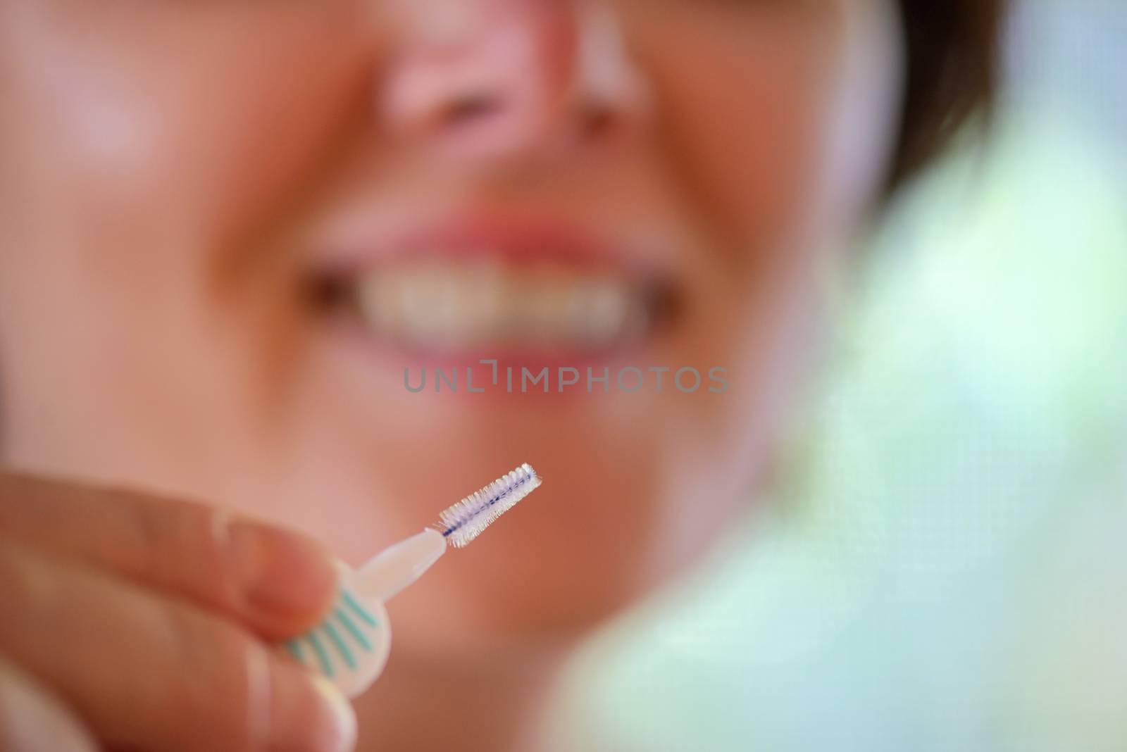 Girl cleaning her teeth with an interdental brush