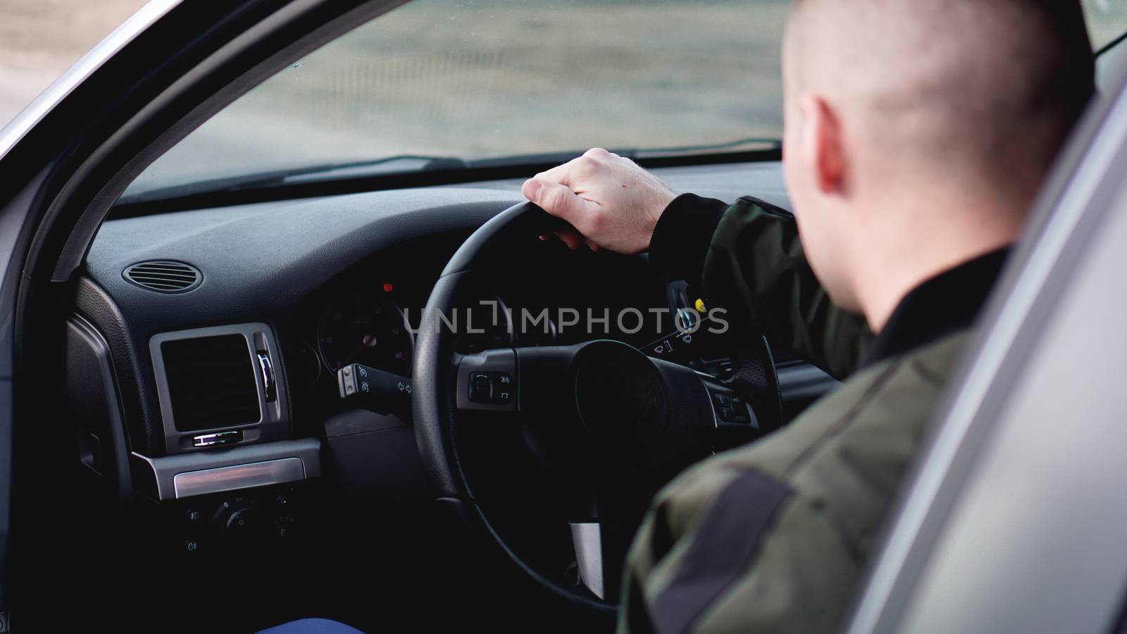 Side view of confident young stylish man driving his car