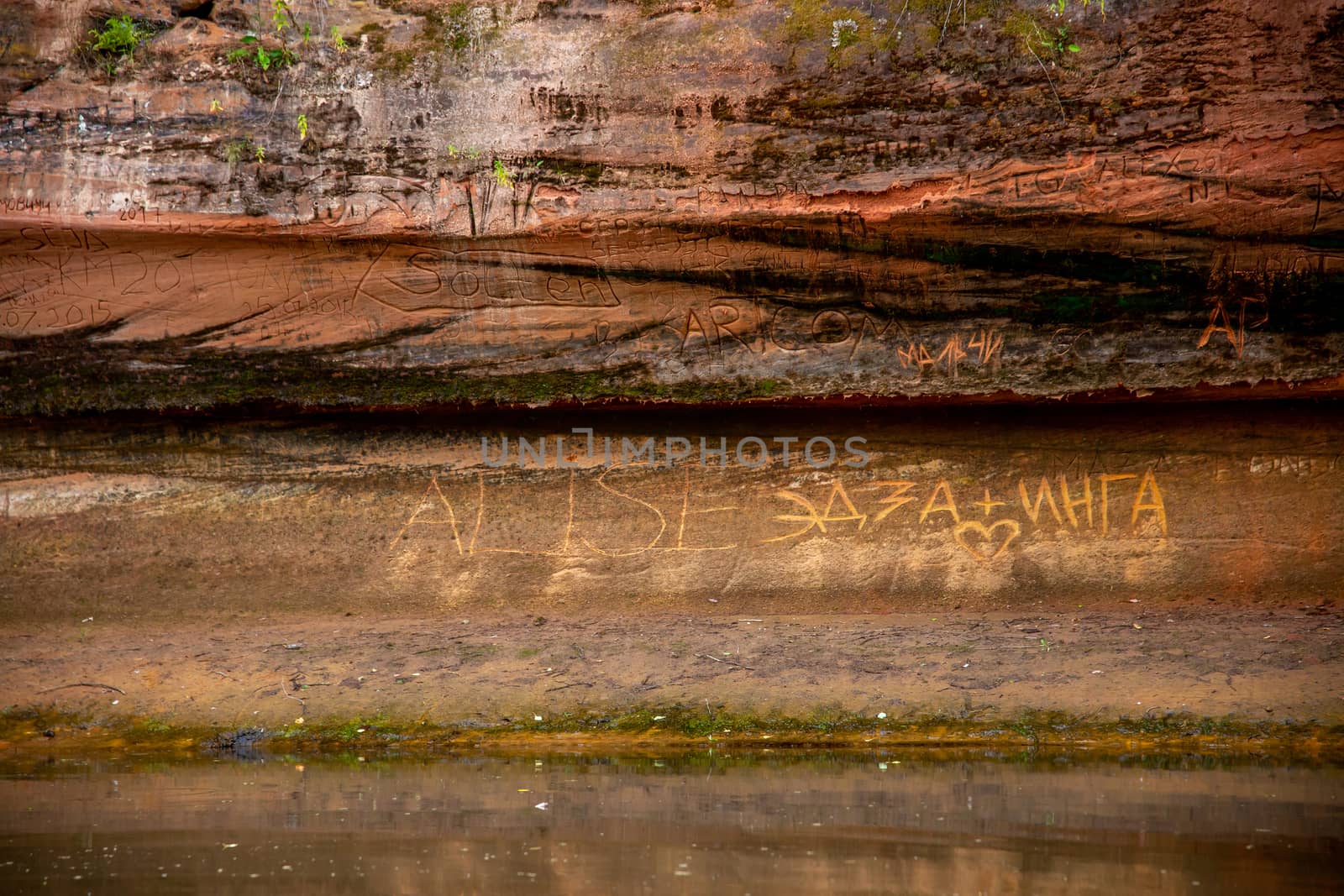 Red sandstone cliff near the river. by fotorobs