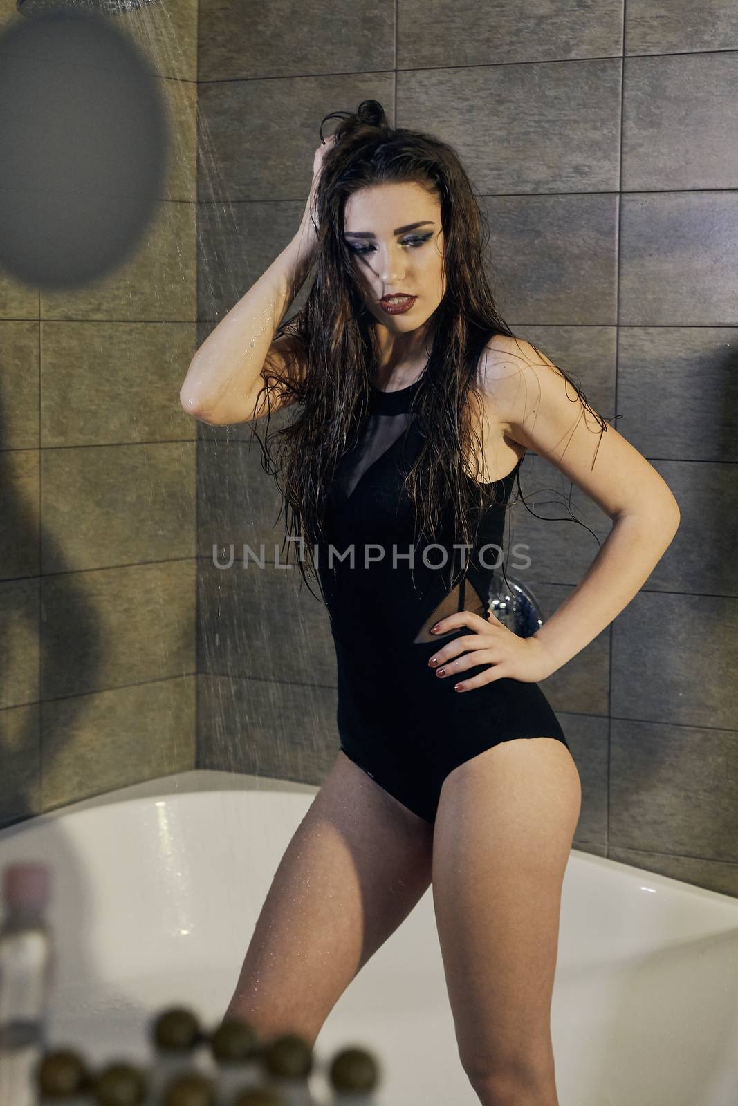 Girl in a black bathing suit taking a shower for concept design. Healthy body care. Model, fashion concept. Skin care concept. Closeup naked girl. Sexy woman portrait. Fresh shower concept.